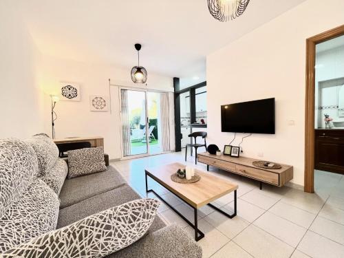 a living room with a couch and a tv at Bungalow Los Balcones in Torrevieja