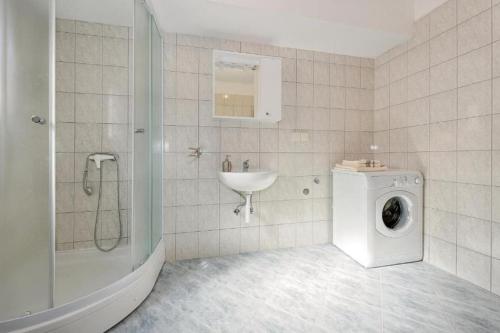 y baño con lavadora y lavamanos. en Villa Annaleah, en Dubravice