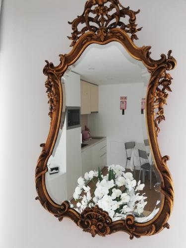 a mirror with a table with white flowers on it at PEARL HOUSE in Aveiro