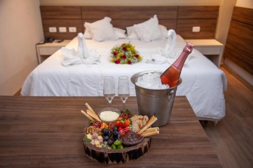 a table with a bottle of champagne and a plate of food at London Hotel in Londrina