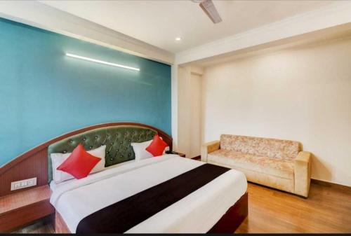 a bedroom with a bed and a chair in it at OYO Admi Suites in New Delhi