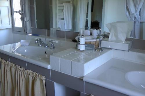 een badkamer met 2 wastafels en een grote spiegel bij Bastide Rose in Le Thor