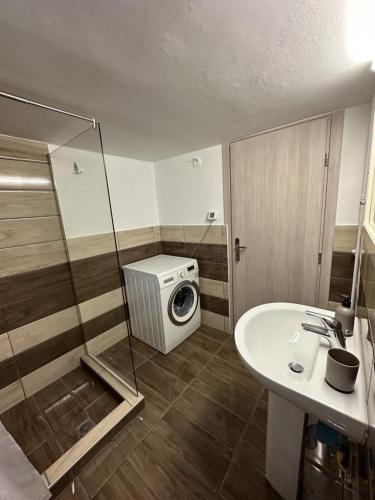 a bathroom with a washing machine and a sink at Όμορφο διαμέρισμα (Αργυρούπολη) in Athens