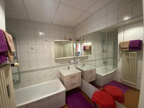 a white bathroom with a tub and a sink and a tub at Ferienwohnung Aktuell in Memmingen