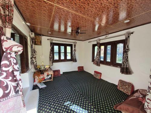 an empty room with chairs and windows in a house at OYO Home Fatima's Homestay in Wāngom