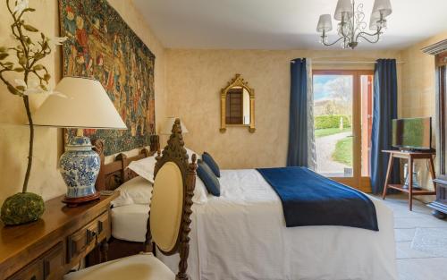 - une chambre avec un lit et une table avec une lampe dans l'établissement La Barde Montfort, votre maison d'hôtes à 4 kms de Sarlat Dordogne, à Vitrac