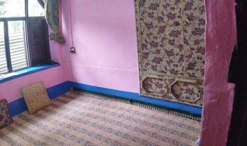 Zimmer mit einer rosa Wand, einem Fenster und einer Tür in der Unterkunft POP Maryam Villa in Gāndarbal