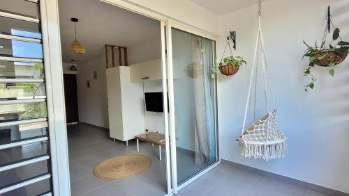 een kamer met een glazen schuifdeur met een schommel bij Ibis Studio in Cayenne