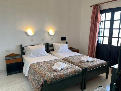 een slaapkamer met 2 bedden en witte kussens bij Angelos Furnished Apartments in Amoopi