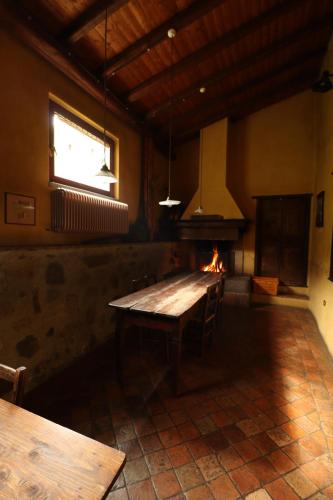 a dining room with a table and a fireplace at Agriturismo Le Frise in Artogne