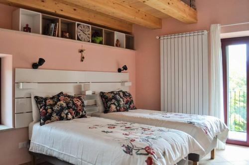two beds in a bedroom with pink walls at Casolare Brindavan: un paradiso nei Monti Sabini in Concerviano