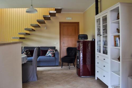 a living room with a blue couch and stairs at Casolare Brindavan: un paradiso nei Monti Sabini in Concerviano