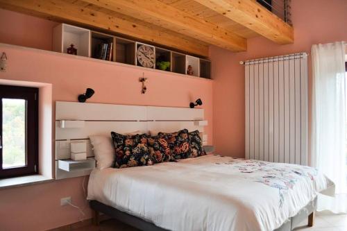 a bedroom with a large bed with pink walls at Casolare Brindavan: un paradiso nei Monti Sabini in Concerviano