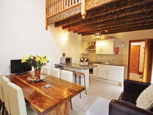 una cucina e una sala da pranzo con tavolo in legno di Plum Cottage a Anderby