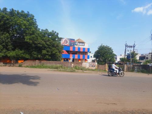 a man riding a motorcycle down the street at OYO Galaxy Lodge in Partūr