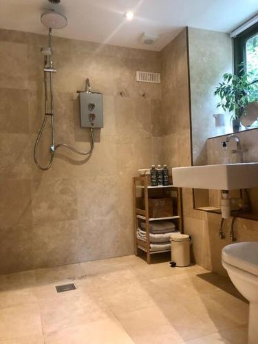 a bathroom with a shower and a sink at The Shippen - Open-plan barn conversion, high-spec, stunning views in Norbury