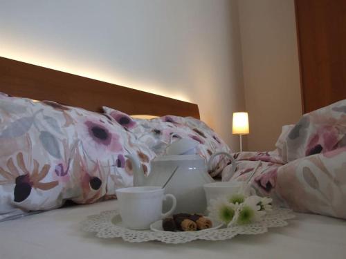 a bed with a plate of food and cups on it at Marconi 33A in Pergine Valsugana