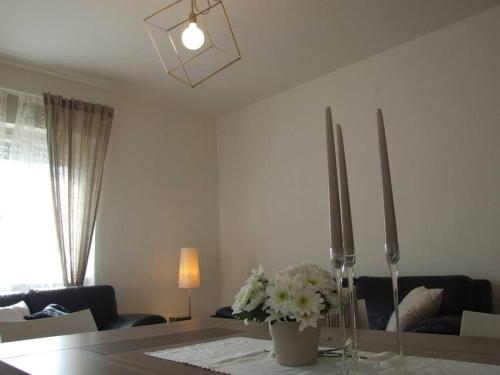 a living room with a table with flowers and candles at Marconi 33A in Pergine Valsugana