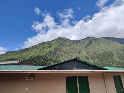 a roof of a building with a mountain in the background at SPOT ON Hotel Rudra in Kulu