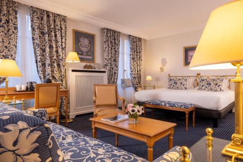 a hotel room with a bed and a couch at Le Littré in Paris