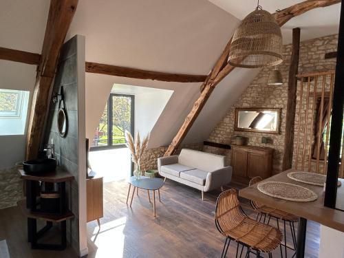 a living room with a couch and a table at Les Noyers De Gaudelle in Saint-Sozy