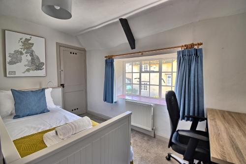a bedroom with a bed and a desk and a chair at Martie Cottage - cosy cottage idyllic village 