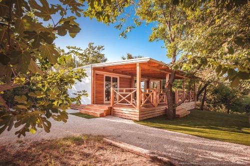 a log cabin with a porch and a yard at Mobilheim Mimi in Nin