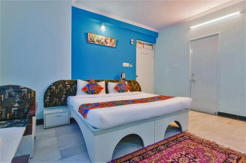 Schlafzimmer mit einem Bett mit blauer Wand in der Unterkunft FabExpress Anuja in Jaipur