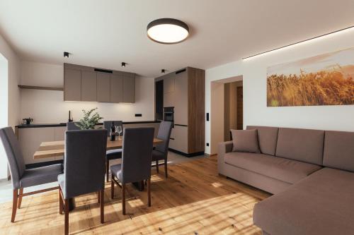 科拉爾博的住宿－Alpenglow Apartments，客厅和带沙发及桌子的用餐室