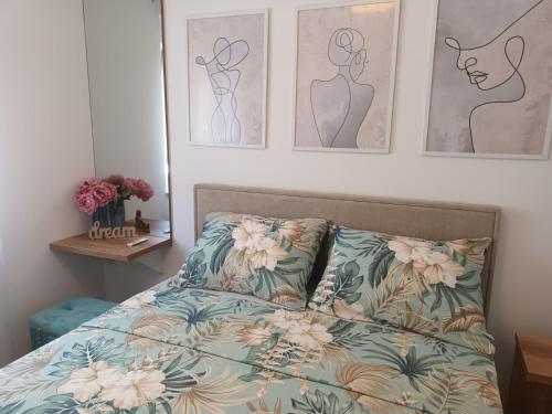 a bedroom with a bed and three paintings on the wall at DREAMS APARTMENT KAŠTELA in Kaštela