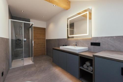 bagno con lavandino e doccia di Alpenglow Apartments a Collalbo