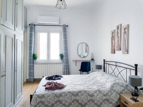 a white bedroom with a bed and a window at Castlevania- Traditional house in the Castle in Naxos Chora