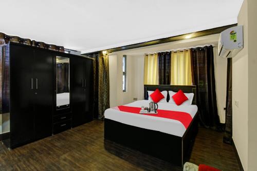 a bedroom with a large bed with red pillows at Flagship Gopika Stay Inn in Nagpur
