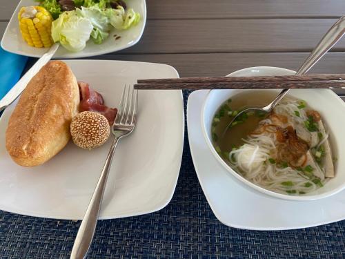 a table with two plates of food and a bowl of soup at La Maison Boutique Hotel in Cao Bằng