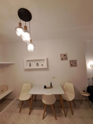 a dining room with a white table and chairs at Studios Irineos in Perissa