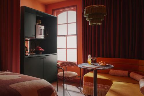 Zimmer mit einem Tisch und einem Bett sowie einer Küche in der Unterkunft Ember Locke Kensington in London