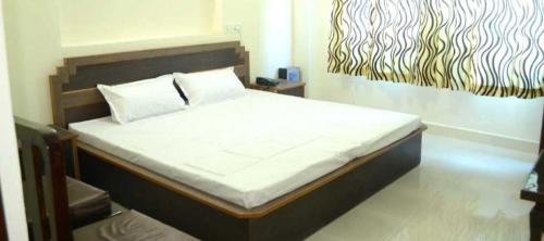 a bedroom with a large bed with a large painting on the wall at OYO Hotel Jk Breeze in Jammu