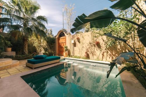 a house with a swimming pool with a palm tree at The Kozyhome in Ouarzazate