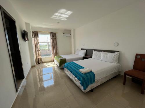 a hotel room with a bed and a chair at Mare S&M Casa Hostal in Manta