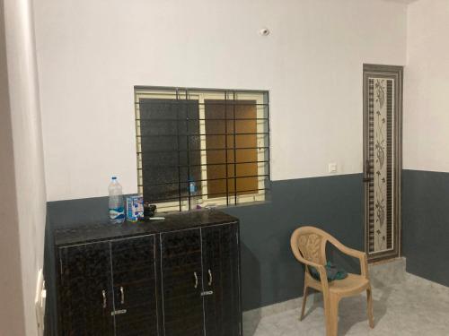 una stanza con una sedia, un comò e una finestra di SPOT ON S L V Residencies a Chāmundi