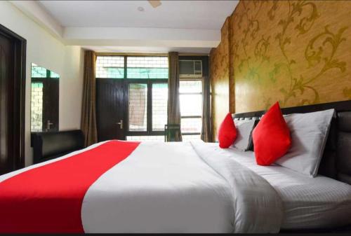a bedroom with a large bed with red pillows at OYO Royal Den Near Lotus Temple in New Delhi