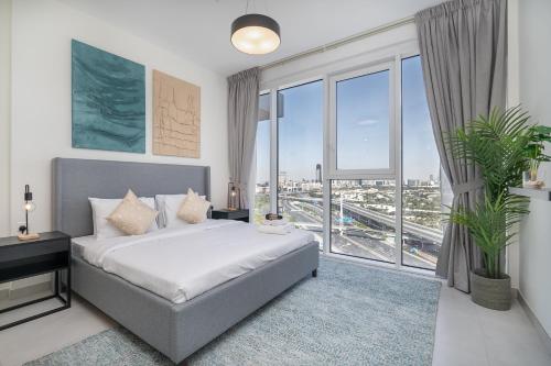 a bedroom with a bed and a large window at Upscale Two Bedroom with Balcony & Free Parking near Zabeel Park by Sojo Stay in Dubai