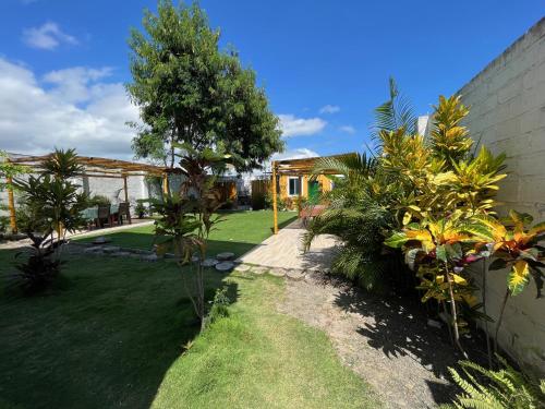 a garden with a lawn and a house at Mare S&M Casa Hostal in Manta