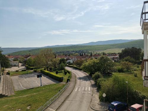 a road in a town with mountains in the distance at AD Apartman Bileća in Bileća