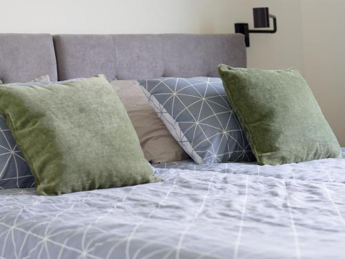 a bed with blue sheets and green pillows at Villa Tea by Rent Istria in Umag