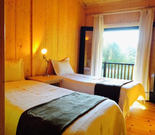 2 Betten in einem Zimmer mit Fenster in der Unterkunft Treehouse Quinta Lamosa in Arcos de Valdevez