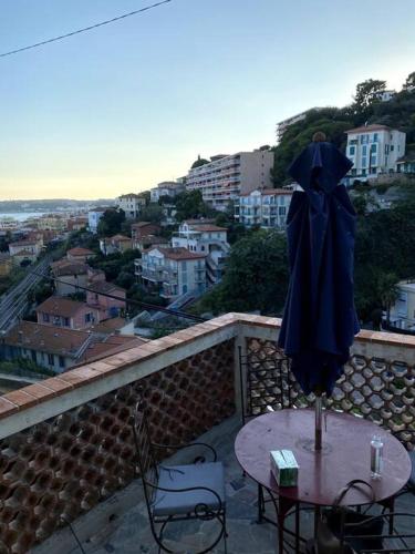 un patio avec une table, des chaises et un parasol dans l'établissement Charmant studio 1, à Menton