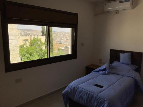 a bedroom with two beds and a large window at Black IRIS in Jerash