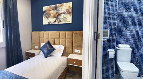 baño pequeño con cama y ducha en HOSTAL MH BORJ, en Martil