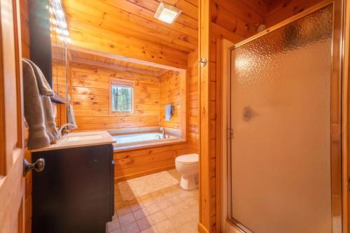 La salle de bains est pourvue d'une baignoire, de toilettes et d'un lavabo. dans l'établissement ADK Cabin with Hot Tub, Near Whiteface, Lake Placid, Fire Pit, Game Rm, à Jay